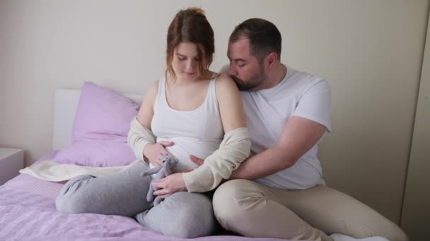 pregnant girl and man in white t-shirts sitting