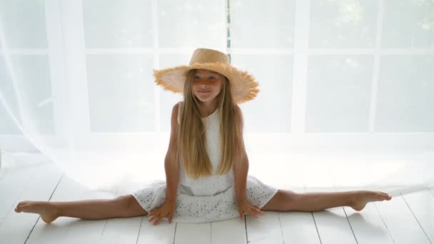 Girl in a white dress sitting on a white floor in a straw hat — Stock Footage Girl in a white dress sitting on a white floor in a straw hat Video Clip