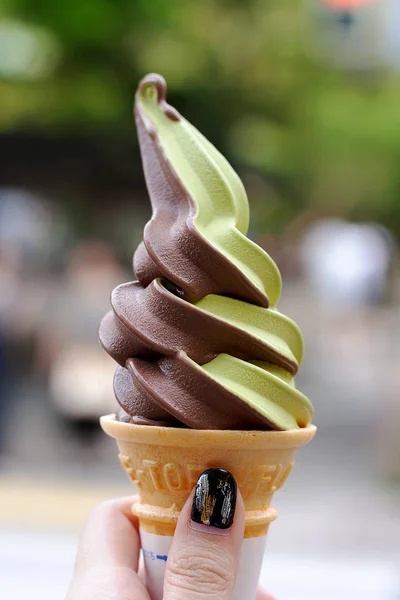 Japanese green tea ice cream. enjoying green tea ice cream cone in japan. a gril holding two-tone ice cream cone.