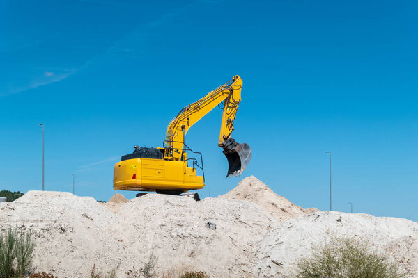 Экскаватор в действии по развитию городов по установке канализационных труб, продвижению инфраструктурных работ