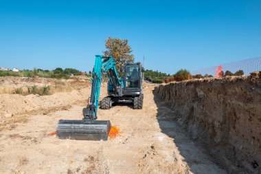 Yedek çapa yükleyici iş başında. Yol genişletmek için toprağı kazıyor.