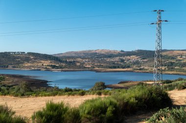 Portekiz 'in başkenti Serra do Alvao' da yüksek voltajlı elektrik hattıyla Gouvaes Barajı 'nın panoramik görüntüsü.
