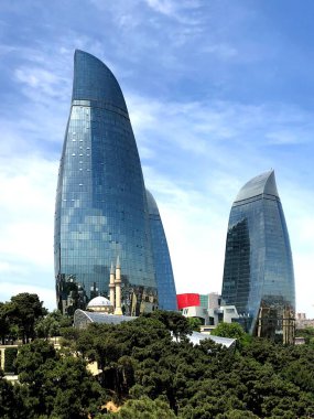 Yanan kuleleri ve bir cami. Eski ve modern mimari yapılar. Bakü Panoraması.