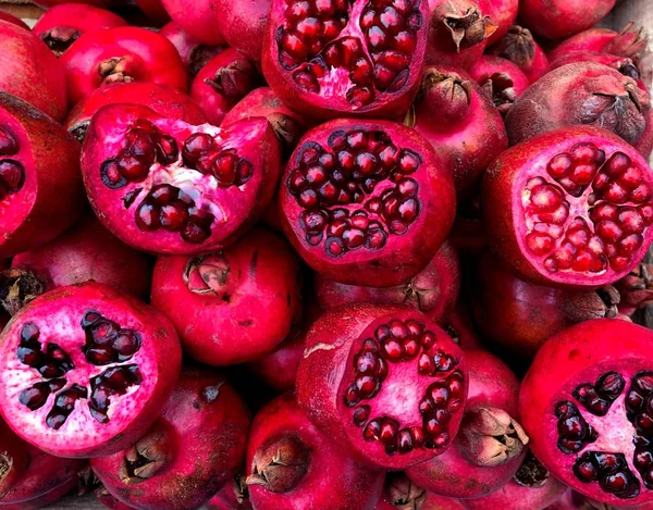 Sliced juicy bright red pomegranates. Fragment from a fruit and vegetable shop.