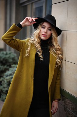 Zeytin ceket ve siyah geniş ekledi şapka giyen genç güzel bir moda bayan açık portresi. Modeli bir kenara arıyorum. Kadın moda kavramı. Şehir bir yaşam tarzı. Yakın çekim.