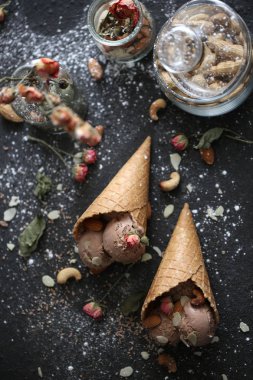 Güzel designigned chokolate dondurma ile fındık ve şeker pund ve güller koyu arka plan üzerinde gözleme kupada tabble üzerinde