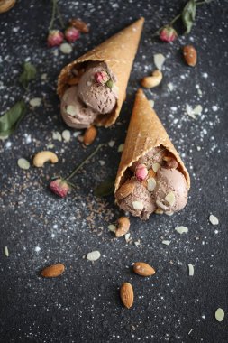 Güzel designigned chokolate dondurma ile fındık ve şeker pund ve güller koyu arka plan üzerinde gözleme kupada tabble üzerinde