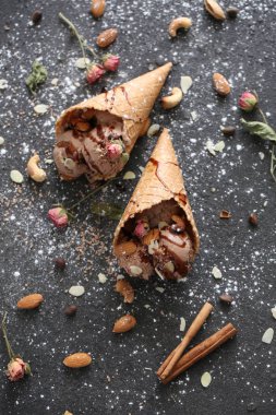 Güzel designigned chokolate dondurma ile fındık ve şeker pund ve güller koyu arka plan üzerinde gözleme kupada tabble üzerinde