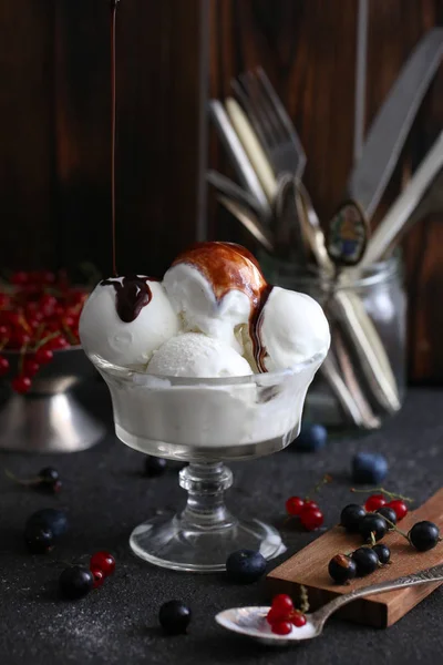 white ice cream with chocolate and red currants