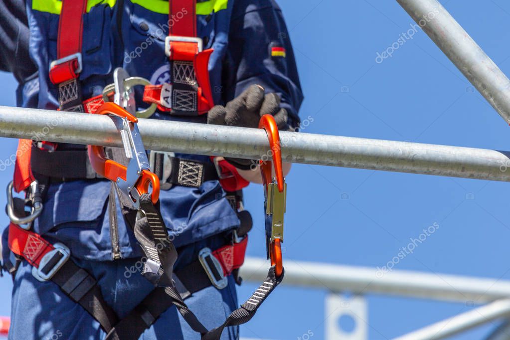 Man from german technical emergency service secured by a carabiner hook
