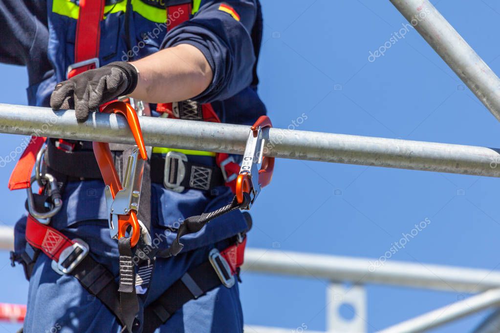 Man from german technical emergency service secured by a carabiner hook