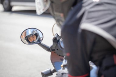 Kadın bir motosiklet üzerinde siyah bir kask ile