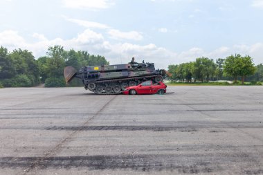 Feldkirchen / Almanya - 9 Haziran 2018: Alman tankı dozer Dachs Feldkirchen Bundeswehr gününde bir kırmızı araba çöker.