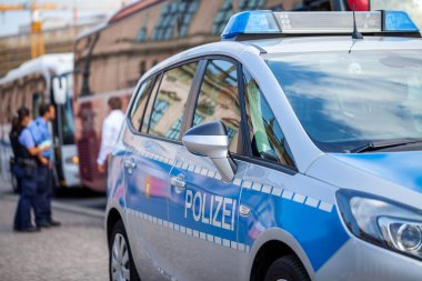 Alman polis arabası sokakta duruyor. İki polis memuru denetimleri trafik. Polizei polis için Alman bir kelimedir