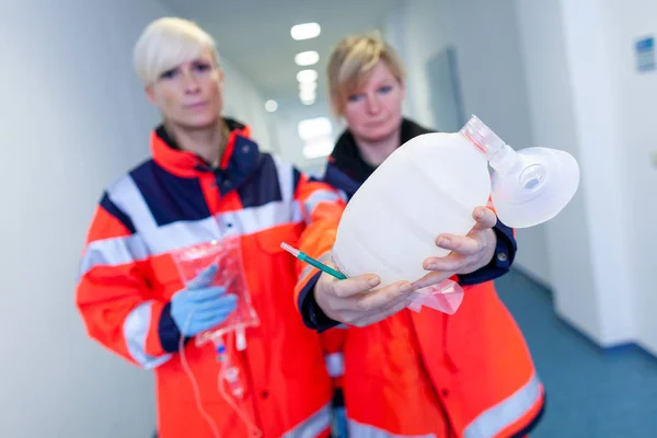 两名女性医护人员在地板上携带急救设备 — 图库照片