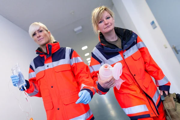 两名女性医护人员在地板上携带急救设备 — 图库照片