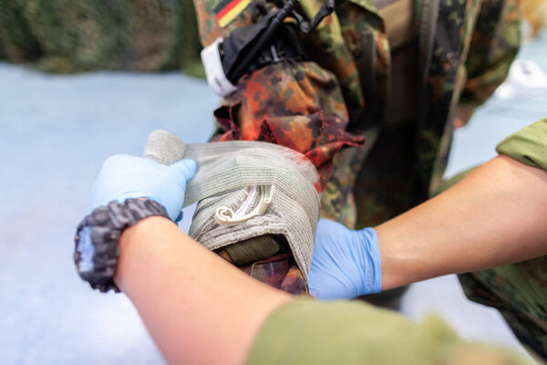 Парамедик создает повязку на переломе.
