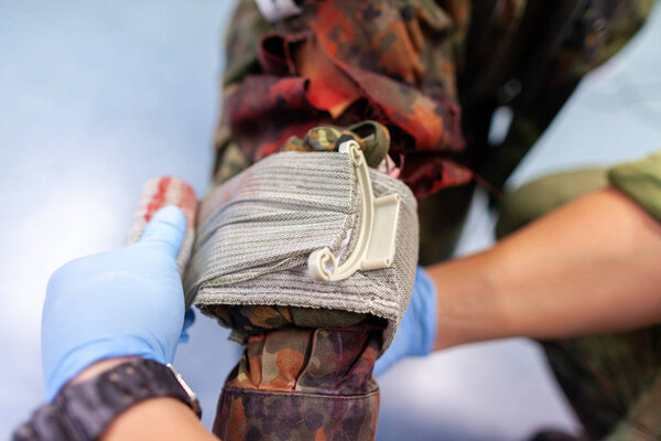 Парамедик создает повязку на переломе.
