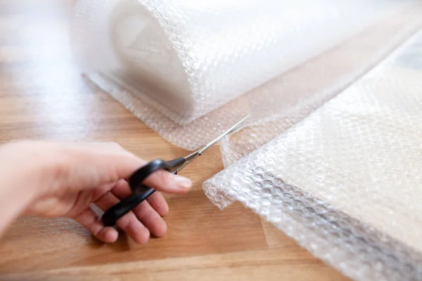 Una Donna Taglia Materiale Imballaggio Con Una Forbice — Foto Stock