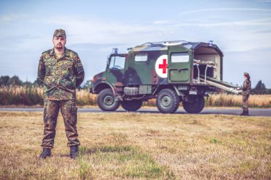 HANNOVER / GERMANY - 24 HAZİRAN 2020: Alman ordusunun sağlık görevlisi askeri ambulansta duruyor