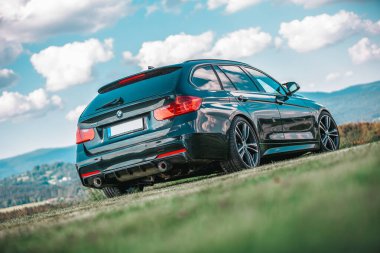 BAVARIA / GERMANY - AĞUSTOS 07.2020: Alman BMW 330 güzel bir bavyera manzarasının önünde duruyor