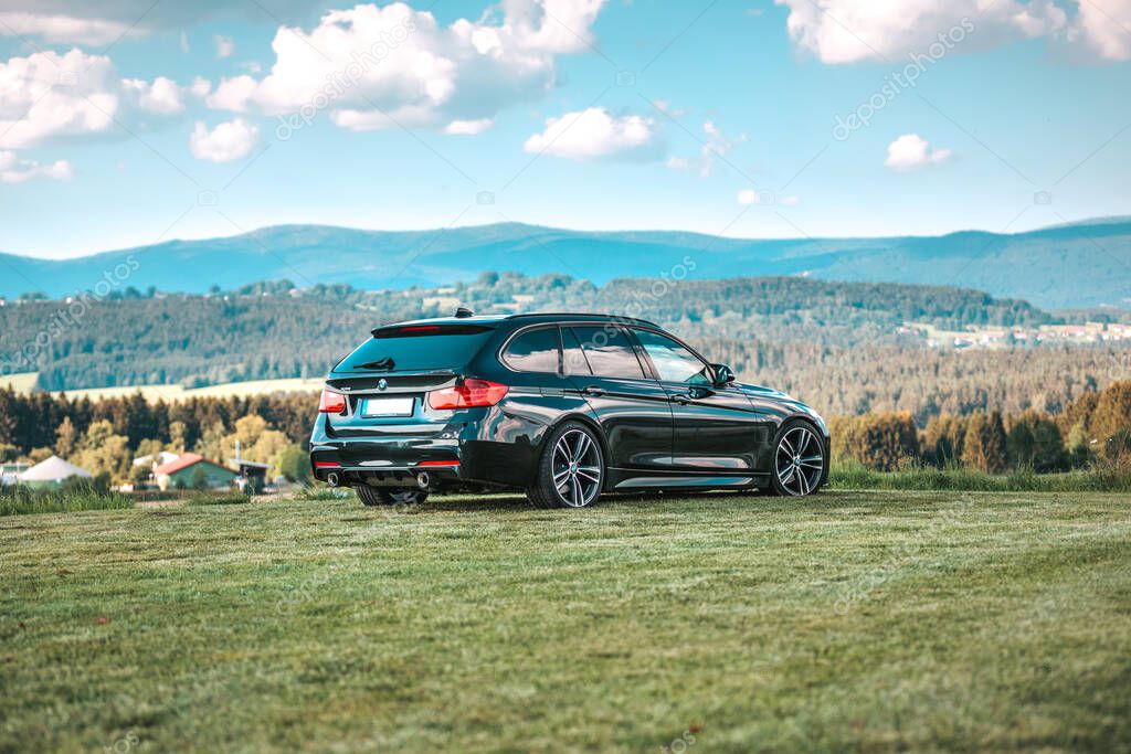 BAVARIA / GERMANY - AUGUST 07,2020: German BMW 330 stands in front of a beautiful bavarian landscape