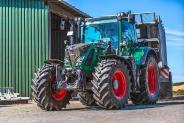 BAVARIA / GERMANY - 20 AĞUSTOS 2020: Yükleyici vagonlu Fendt traktörü, bir biyogaz fabrikasında çalışıyor