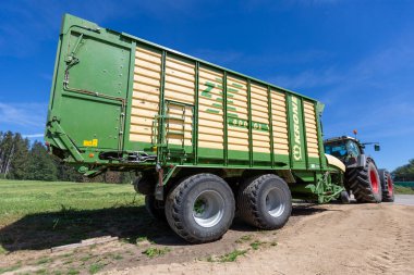 BAVARIA / GERMANY - 20 AĞUSTOS 2020: Yükleyici vagonlu Fendt traktörü, bir biyogaz fabrikasında çalışıyor