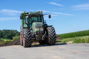 BAVARIA / GERMANY - 20 AĞUSTOS 2020: Yükleyici vagonlu Fendt traktörü, bir biyogaz fabrikasında çalışıyor