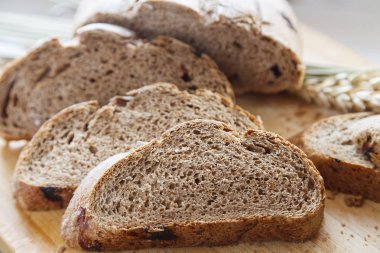 ahşap bir masaya ekmek buğday kulakları ile dilimlenmiş