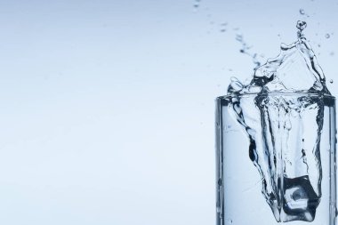 Splash su buz dilim beyaz arka plan yakın çekim üzerinde Kupası Cam