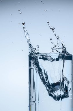 Splash su buz dilim beyaz arka plan yakın çekim üzerinde Kupası Cam