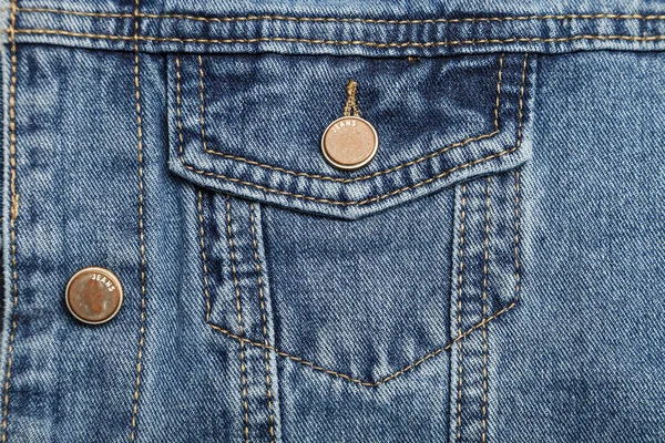 pocket on denim jacket close-up, blue jeans