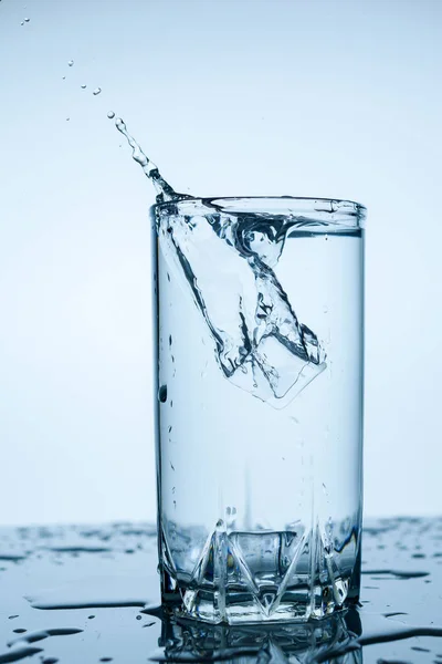 Splash Water Glazen Beker Met Ijs Slice Witte Achtergrond Close — Stockfoto