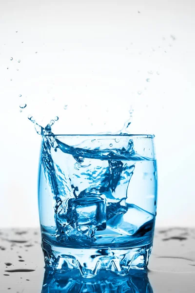 Agua Salpicada Vaso Con Trozo Hielo Sobre Fondo Blanco Trozo — Foto de Stock