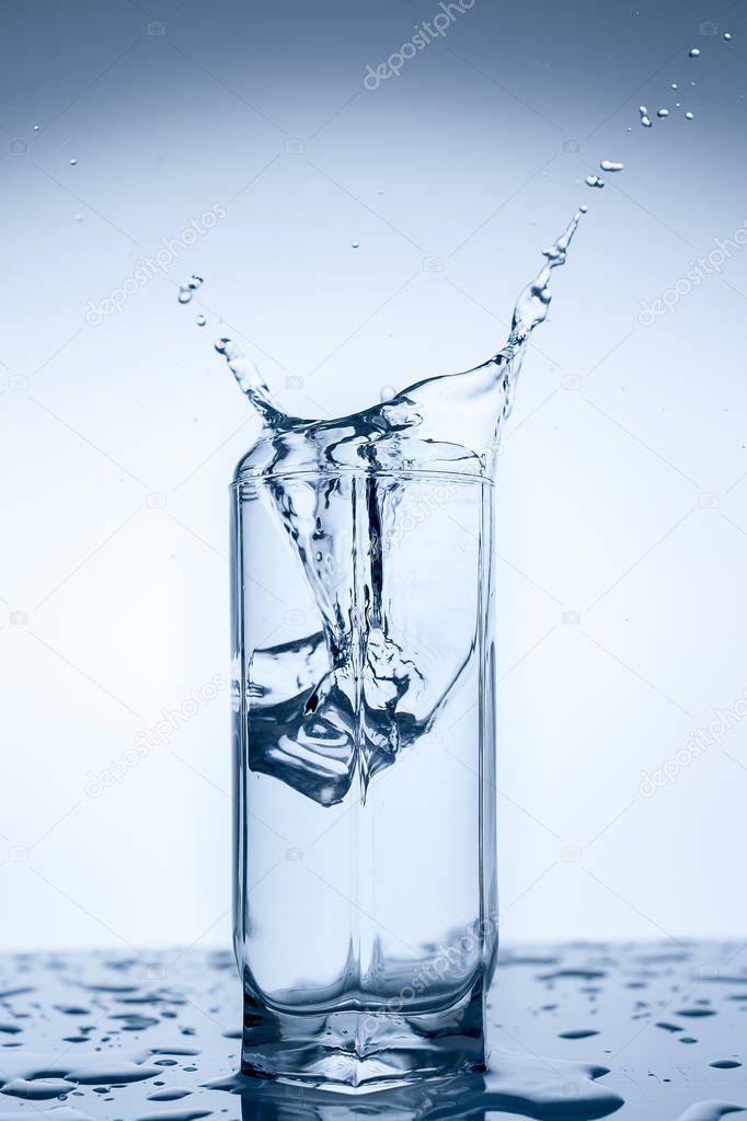 Splash Of Water In Glass Cup With Ice Slice On White Background Close Up Larastock