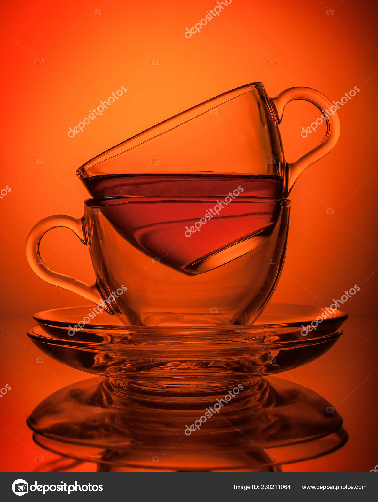 两杯透明玻璃制成的茶面朝对方背景是茶托橙色 图库照片 C Borisblik