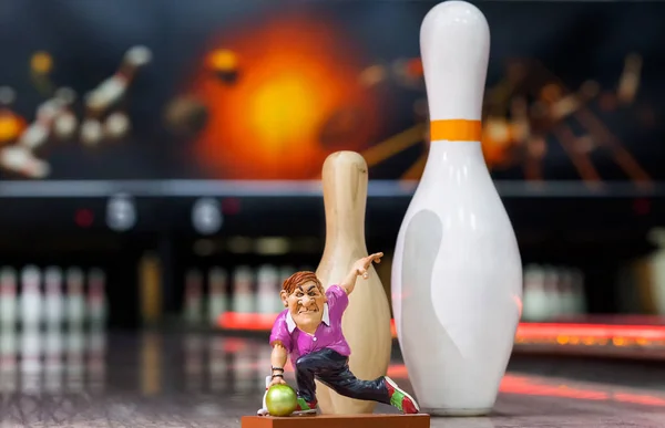 a man throws a ball against the background of bowling, the toy layout