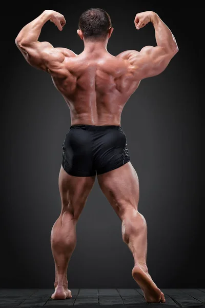 Klassiska Bodybuilder Visar Hans Ryggmusklerna Spänning Mot Grå Bakgrund — Stockfoto