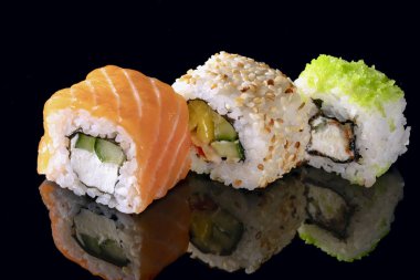 yansıması ile siyah arka plan üzerine geleneksel taze Japon Suşi rulo