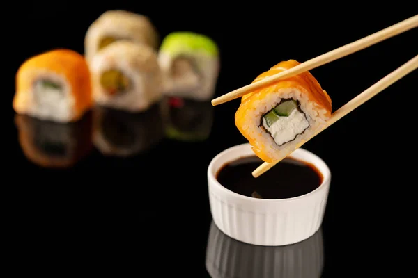 Sushi Gulung Dengan Sumpit Latar Belakang Hitam — Stok Foto