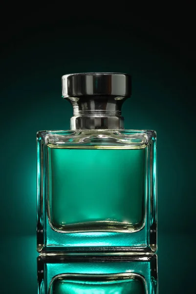 a bottle of men\'s perfume on a green background with a reflection