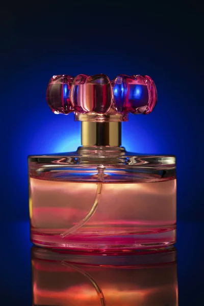 bottle of women\'s perfume pink on blue background