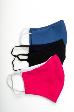 Koronavirüse karşı üç koruyucu yüz maskesi, siyah, mavi, kırmızı, beyaz arka planda izole edilmiş.