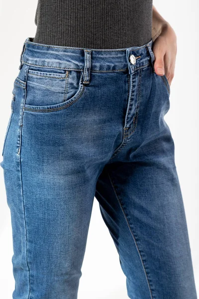 穿牛仔裤的女孩把牛仔裤的前半部分展示在白色背景的紧身衣蓝色牛仔裤上 — 图库照片