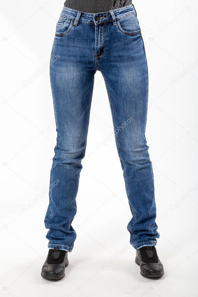 girl in jeans shows jeans on a white background close-up, blue jeans
