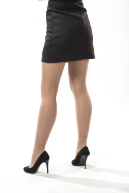 Beyaz arka planda kısa siyah etekli, güzel ince bacaklı, kısa etekli kız.