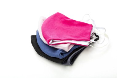 Beyaz arka planda izole edilmiş yoğun kumaştan yapılmış koronavirüse karşı koruyucu yüz maskesi yığını.