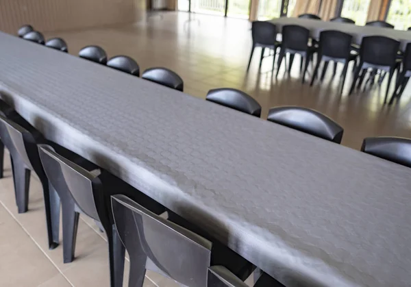 Shot of a row of plastic grey chairs around tables covered in grey paper tablecloths getting in preparation of festivities.