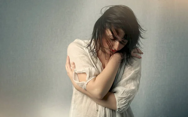 Studio portret van een jong meisje snlelijk knuffelen zichzelf — Stockfoto
